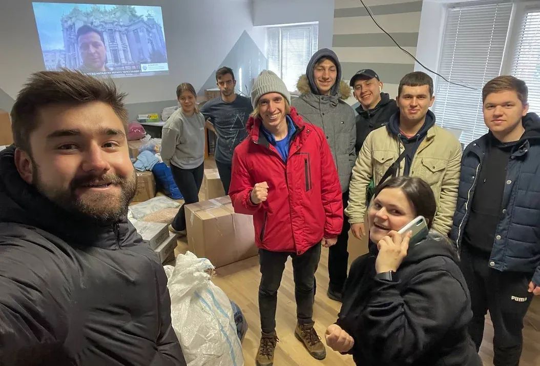 People standing in a room surrounded by boxes of humanitarian aid.