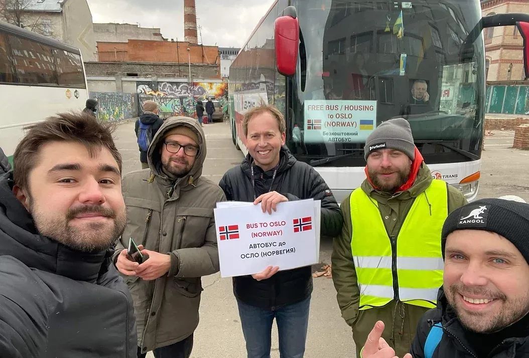 Five men standing in front of a bus.