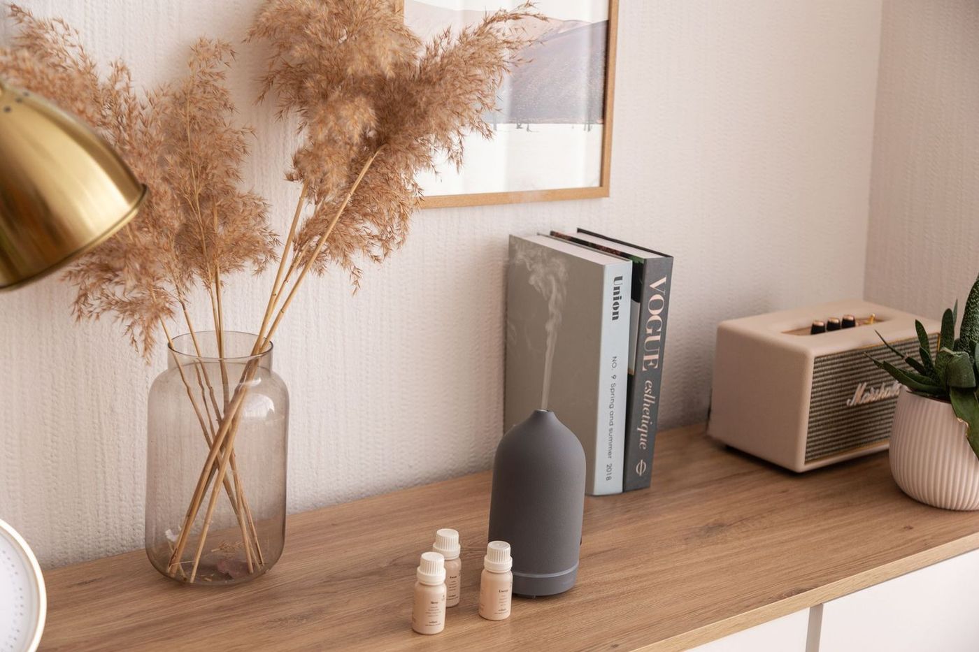 Black essential oil diffuser next to oil vials