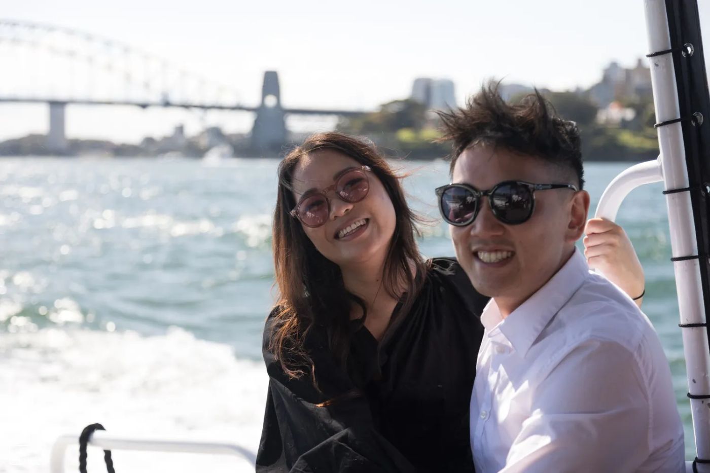 man and woman on harbour cruise, smiling, wearing sunglasses. 